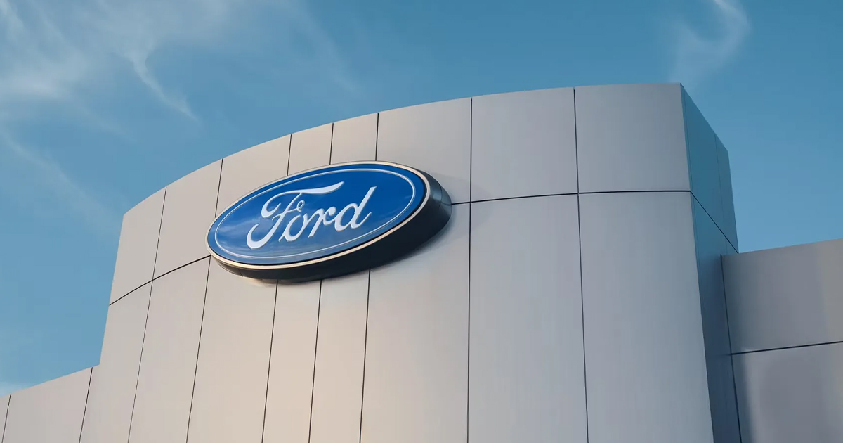 Ford logo on white modern building exterior with blue sky background